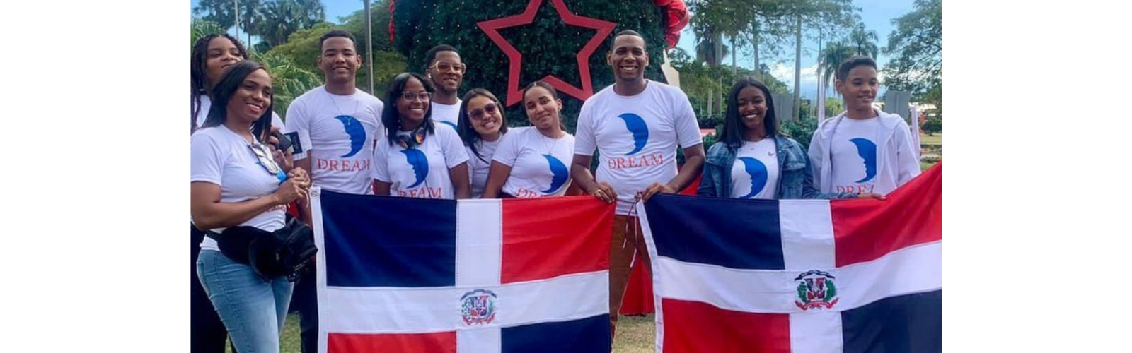 Students are gathered for a photo. They are holding up two flags and smiling at the camera.
